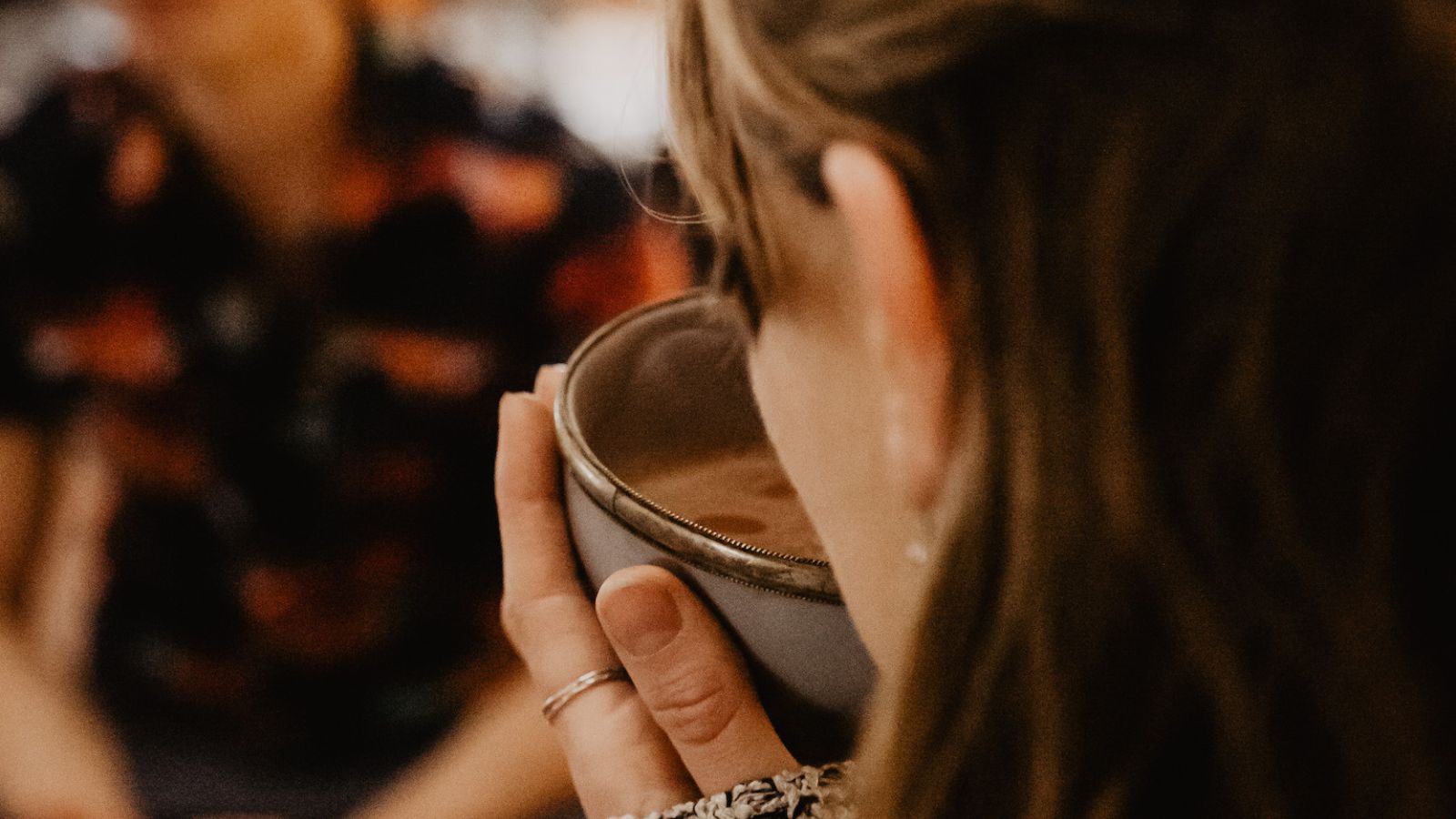 Junge Frau trinkt zeremoniellen Kakao aus einer Tasse